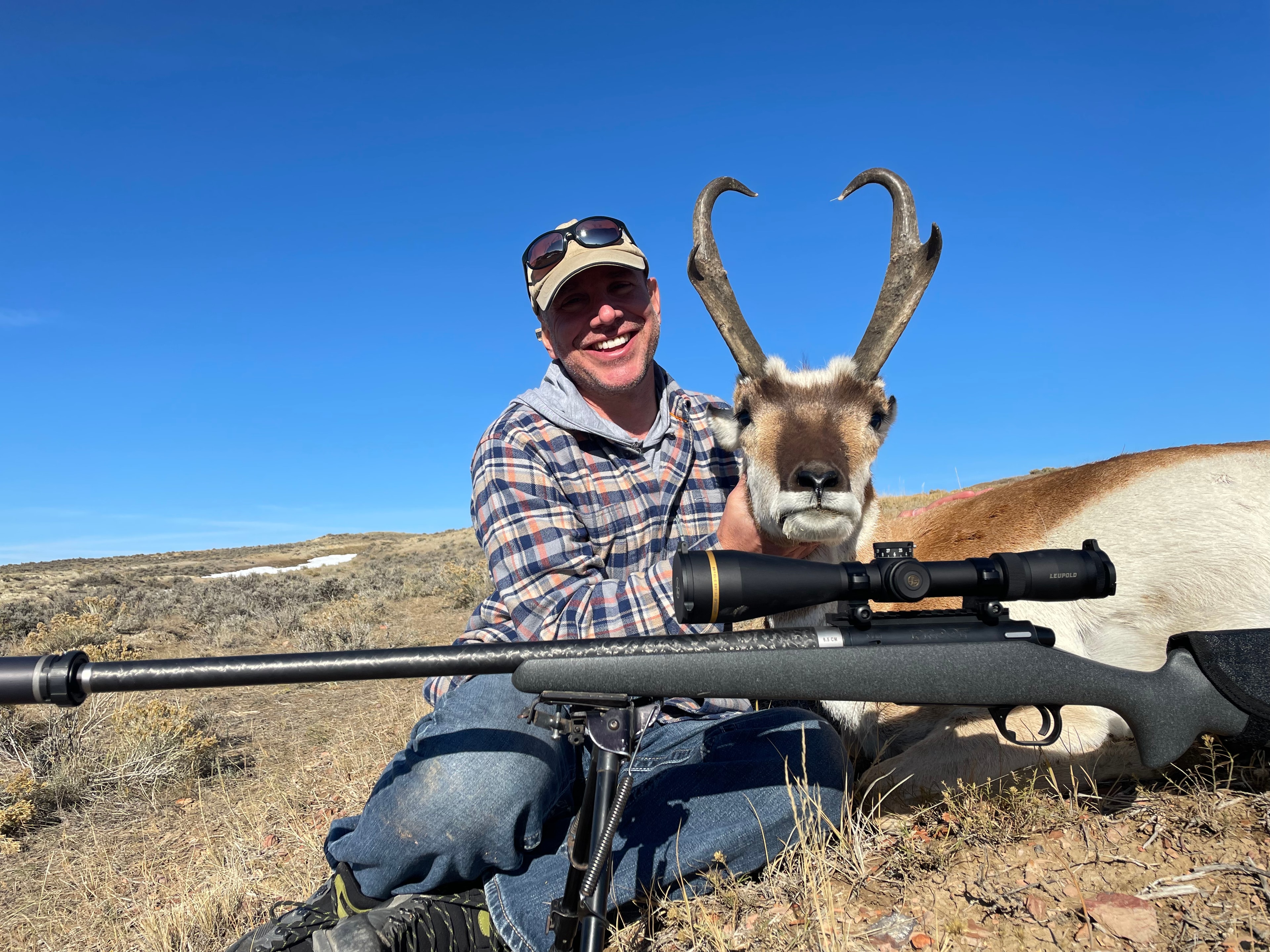Hunter with antelope and Leupold scoped rifle on bipod