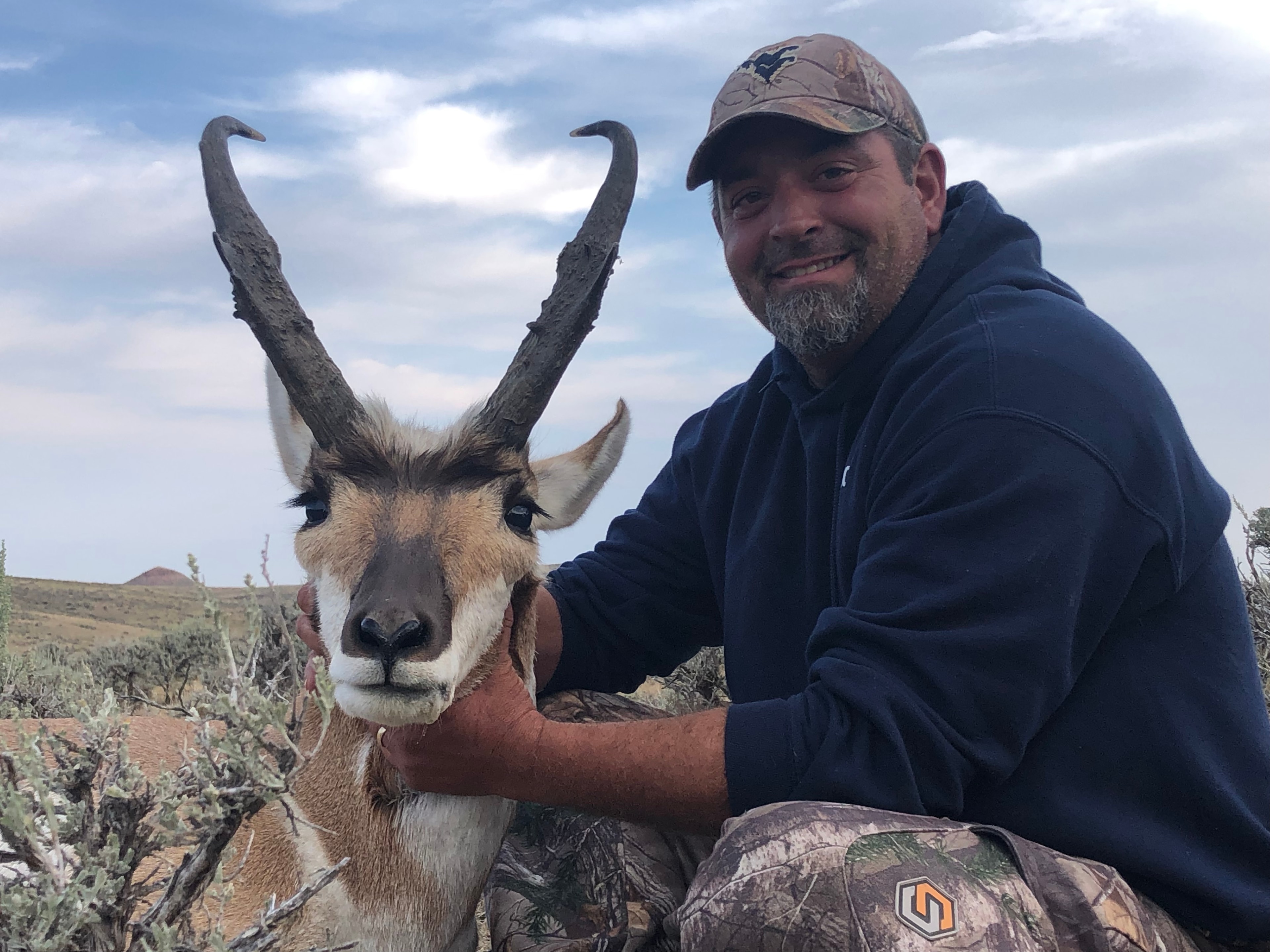 Hunter with harvested antelope in sagebrush