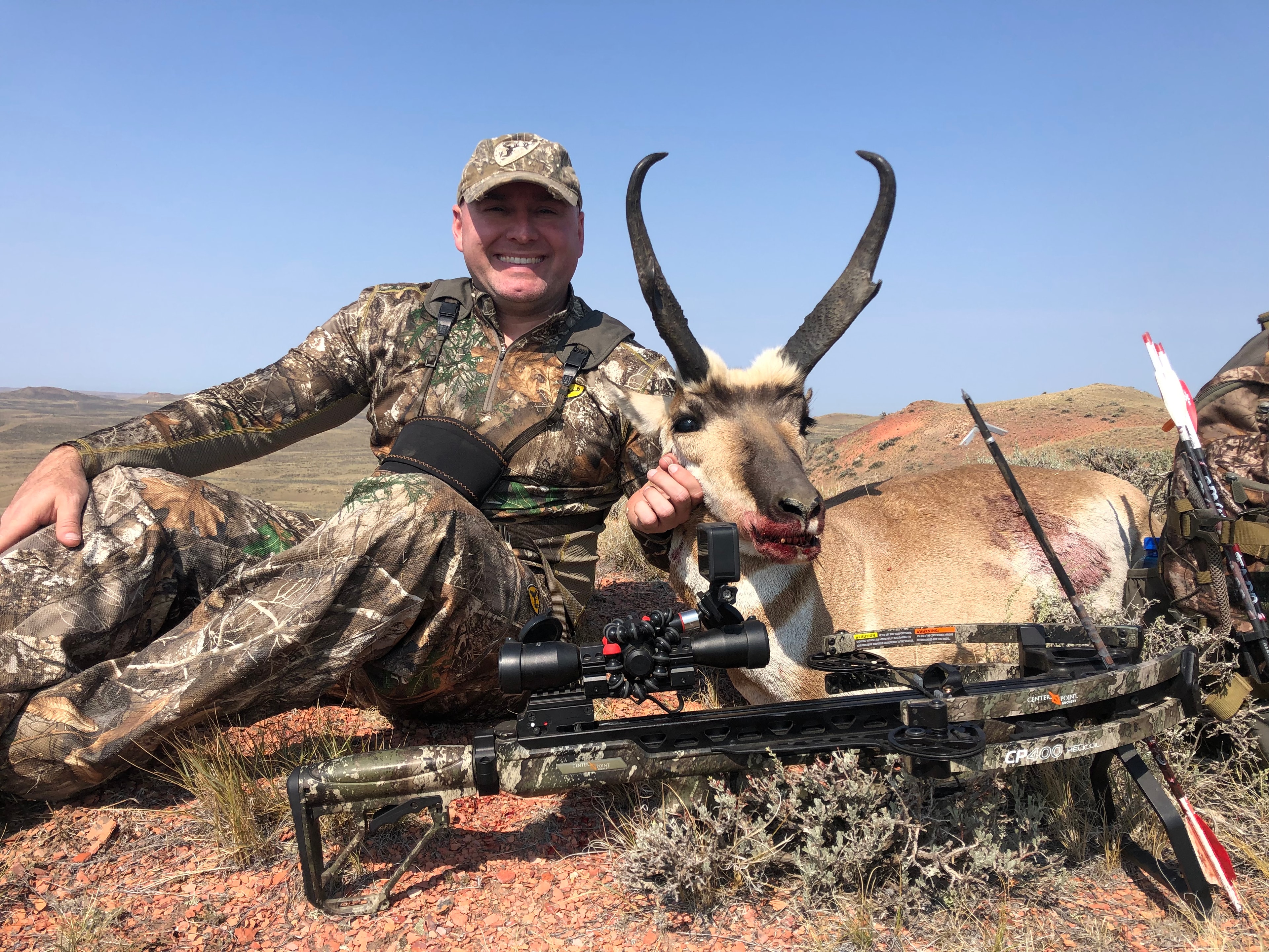 Hunter with antelope and crossbow in red rock terrain